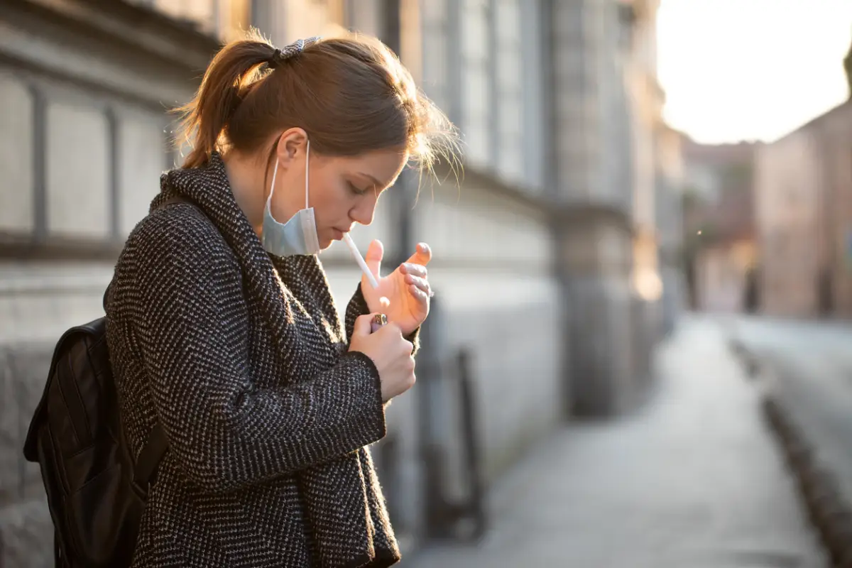Mujer joven encendiendo un cigarrillo