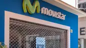 Fachada azul de una tienda de servicio al cliente de Movistar con el logo de la empresa