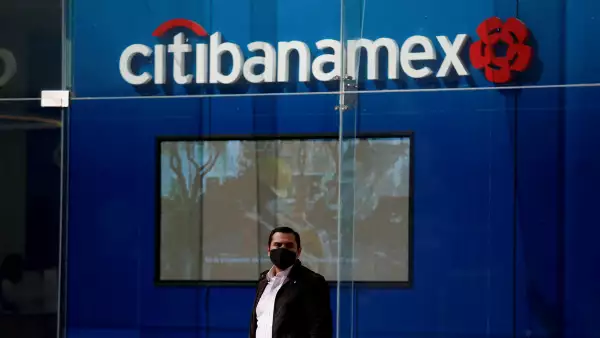 (Un hombre canima frente a una sucursal de Citibanamex)