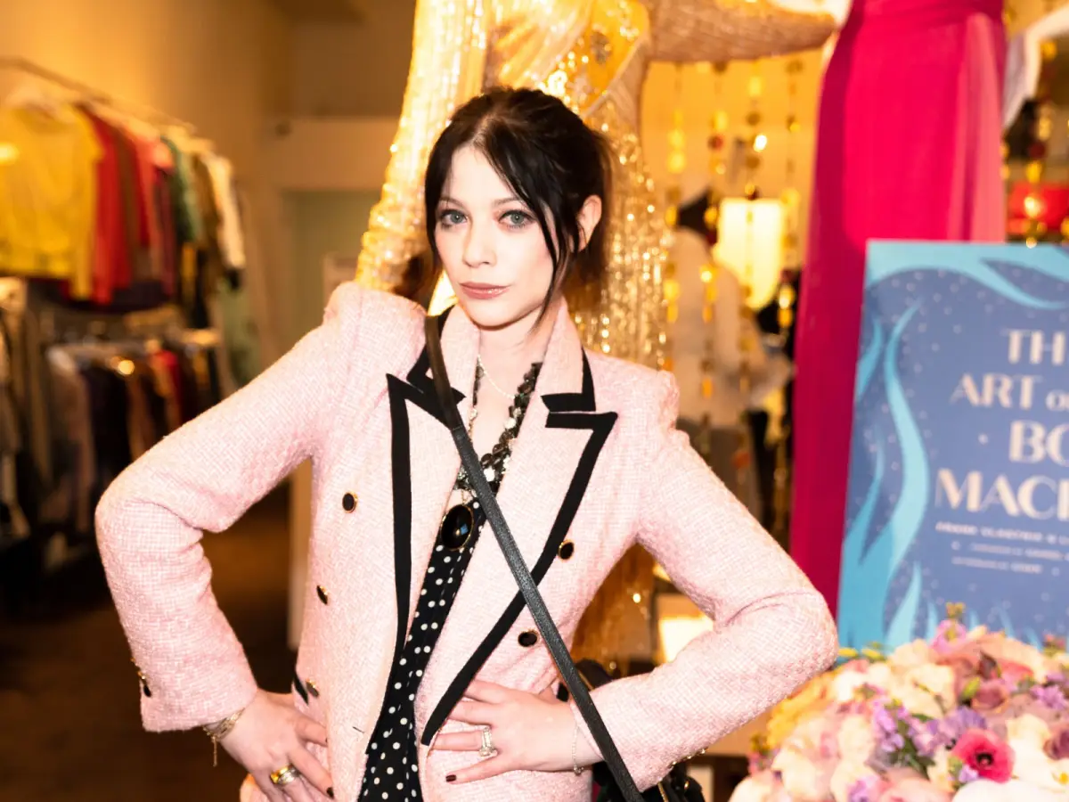 Foto de la actriz Michelle Trachterberg en 2021, con un saco rosa y cabello recogido.