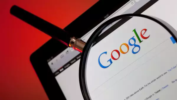 Trucos para borrar correos en Gmail de forma masiva. (Un navegador de Google con una lupa sobre el logo).