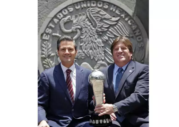Peña Nieto y Miguel Herrera sosteniendo el trofeo del campeonato.