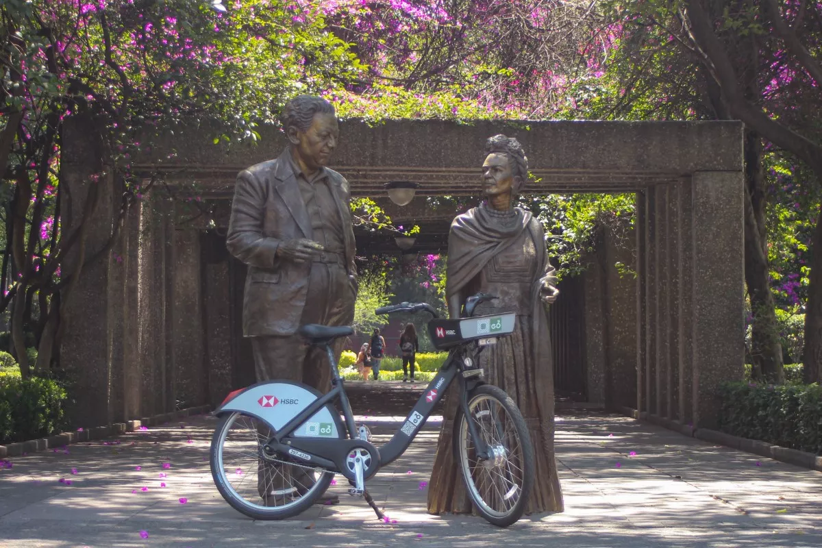 Una bici de Ecobici frente a las esculturas de Diego Rivera y Frida Kahlo en Coyoacán.