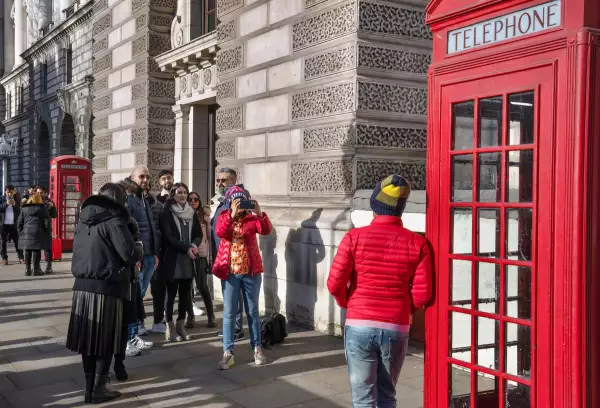 A un turista le toman una foto junto a una cabina telefónica británica a la antigua el 30 de enero de 2023 en Londres, Inglaterra.