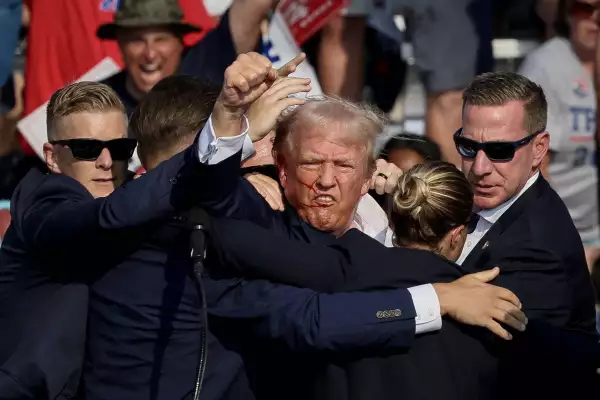 El candidato presidencial republicano y expresidente de los Estados Unidos, Donald Trump, es asistido por el Servicio Secreto después de que se disparara durante un mitin de campaña en el Butler Farm Show en Butler, Pensilvania, EE. UU., el 13 de julio de 2024.