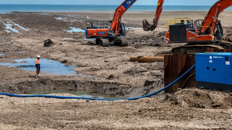 Hombres y máquinas en un terreno extrayendo agua del subsuelo.