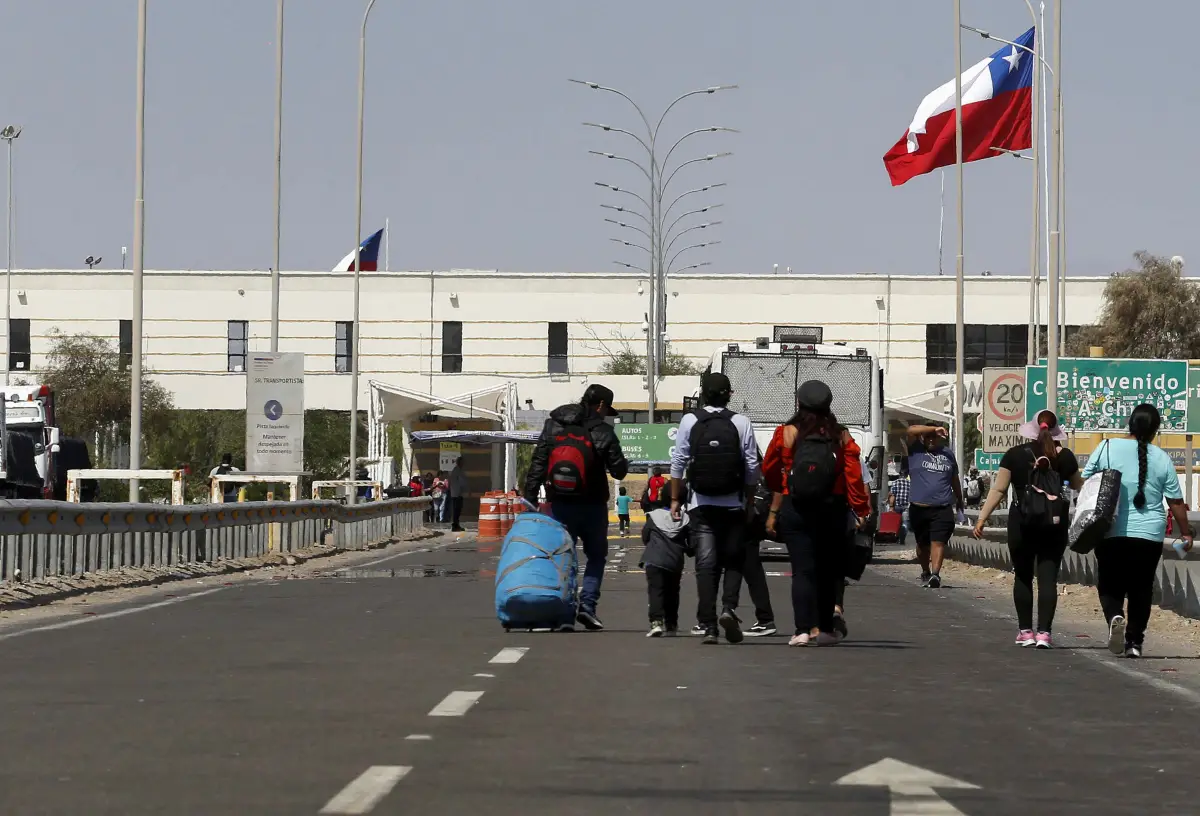 La gente camina hasta la entrada fronteriza de Chile, mientras que los migrantes indocumentados, en su mayoría de Venezuela, Colombia y Haití, permanecen atrapados en Chile, después de que Perú se negara a abrir sus fronteras a los migrantes que regresaban a sus países, según los medios de comunicación locales, en el área de Chacalluta, Arica, Chile, el 29 de abril de