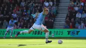 Foto de Erling Haaland en un partido del Manchester City tirando a gol el balón.