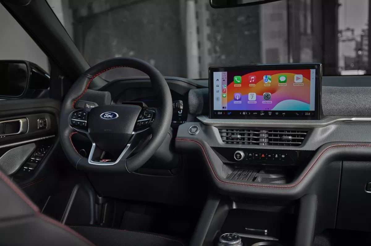 Interiores de SUV Ford Explorer ST 2025. Se observa el volane y el tablero, equipado con sonido y espacio para colocar un smartphone e interactuar con el vehículo