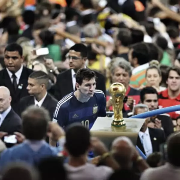 Lionel Messi pasa junto al trofeo de la Copa del Mundo en el estadio Maracana durante el Mundial de Brasil. Autor: Bao Tailiang. Categoría: Deportes.
