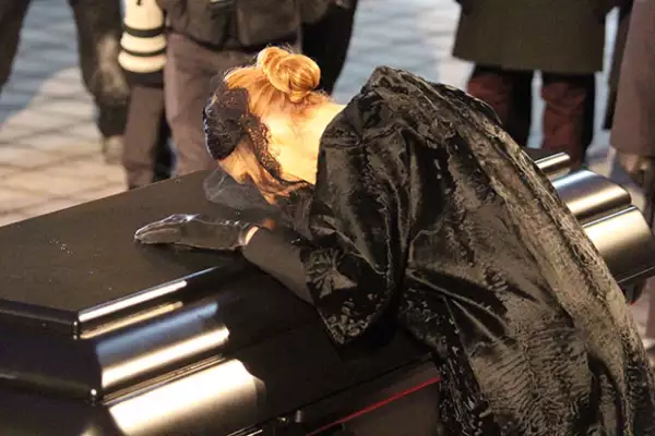 La cantante se apoyó en el féretro para despedirse.