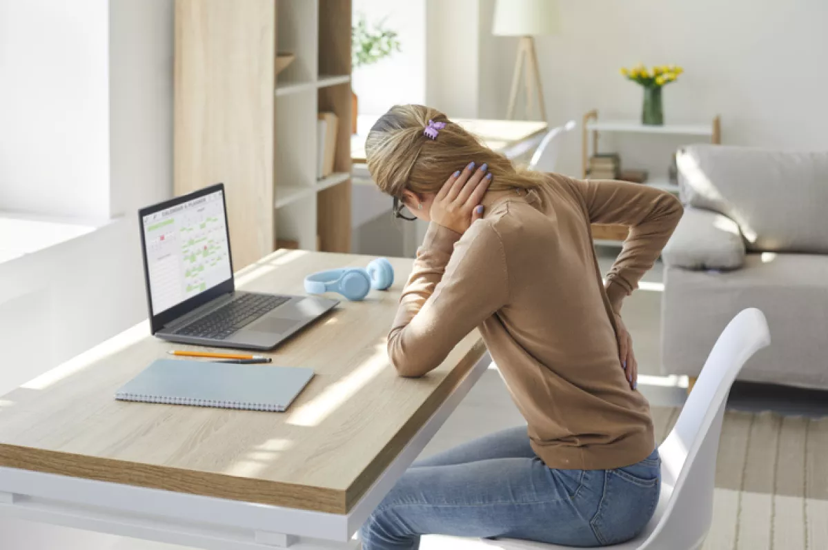 Woman who works in sitting posture on her laptop computer is suffering from back pain