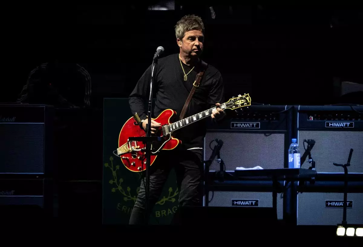 Foto de Noel Gallagher tocando su iconica guitarra roja durante el concierto de Oasis en México.