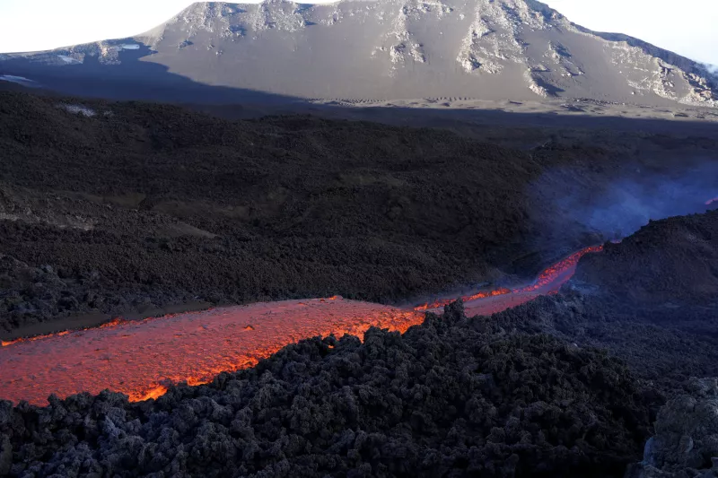 Largos arroyos de lava al rojo vivo fluyen por el cráter sureste del Monte Etna, el volcán más alto y activo de Europa, visto desde Zafferana Etnea, Italia, el 11 de junio de 2022. Foto tomada el 11 de junio de 2022.