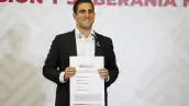 Eugenio Segura Vázquez, coordinador de Morena en Quintana Roo, muestra su comprobante de registro al proceso interno de Morena.