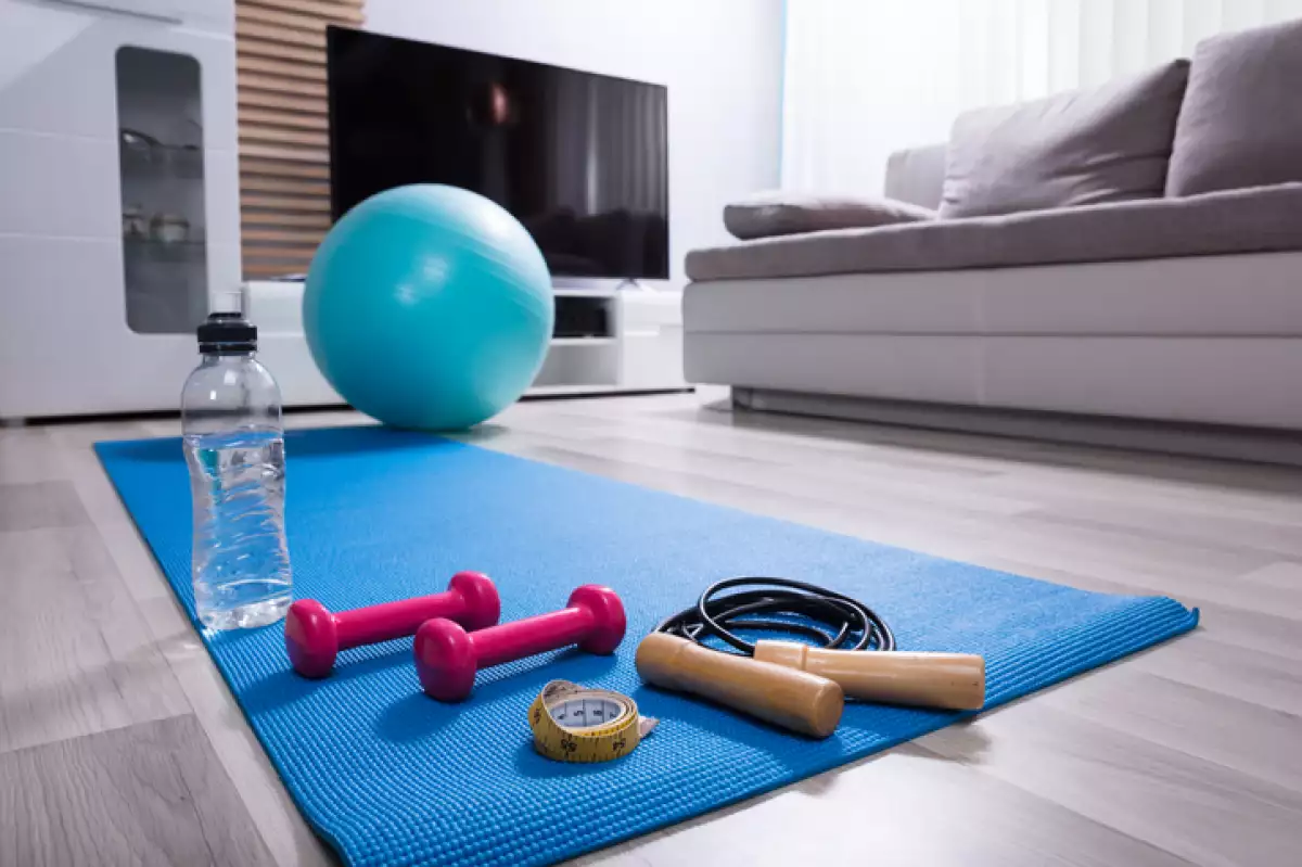 Cuerda, pesas, agua, cinta métrica y pelota sobre mat de ejercicio.