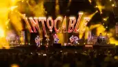 Cuatro músicos con en un escenario con luces de color rojo.jpg