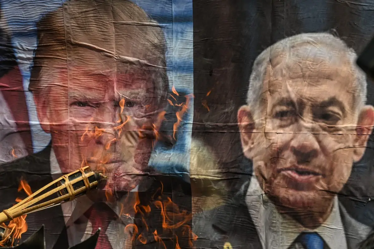 Un hombre quema una foto del presidente estadounidense Donald Trump y el primer ministro israelí Benjamin Netanyahu durante una protesta contra la acción militar entre Estados Unidos e Israel en Irán, cerca de la Embajada de los Estados Unidos en Manila el 9 de abril de 2026.