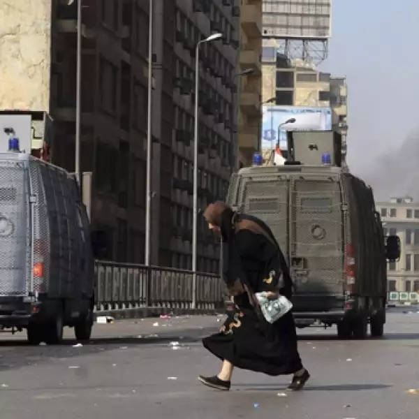 una mujer cruza una calle en durante los enfrentamientos