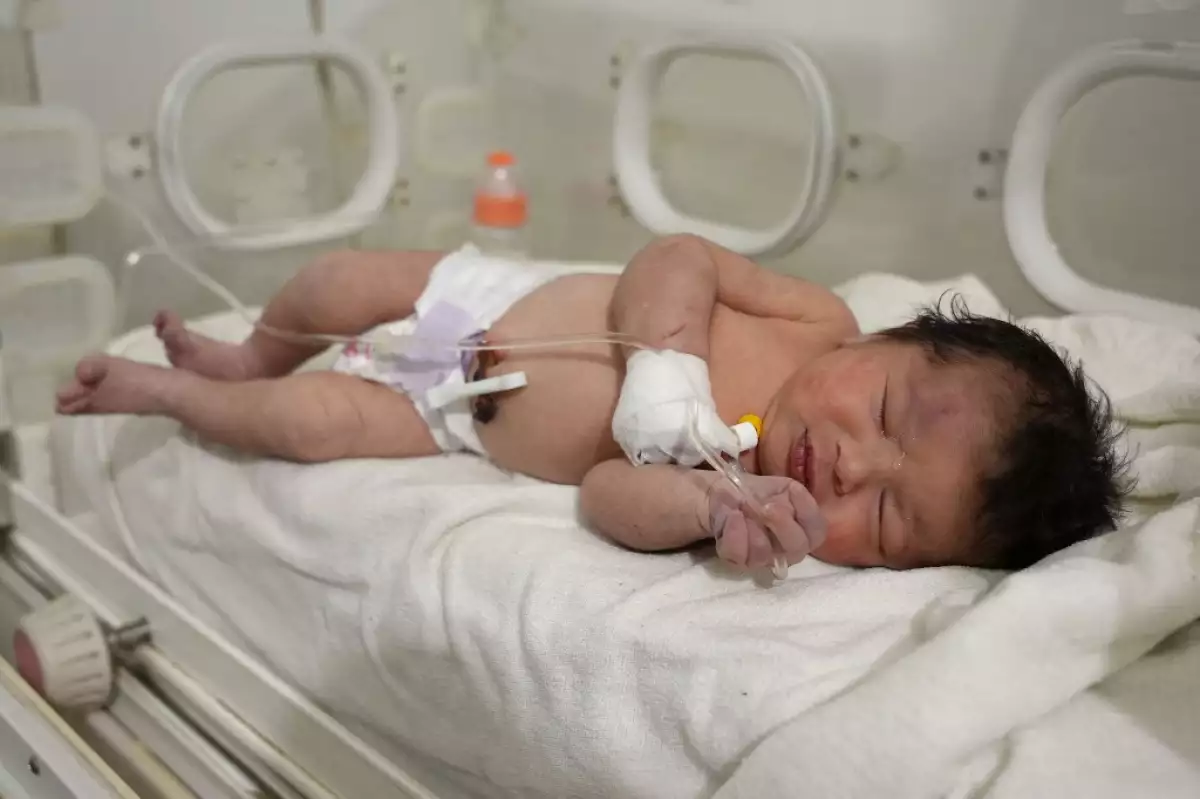 Una bebé recién nacida que fue encontrada aún unida por el condón umbilical a su madre fue encontrada viva en los escombros de un edificio en siria. En la foto, recibe está en una incubadora. 