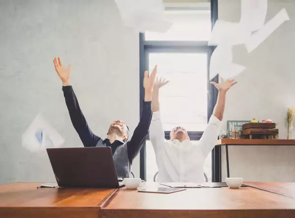 Two of young businessman trowing papers papers/sheets for work after finishing work, successful in business target in modern office, feeling happy, cheerful and relax