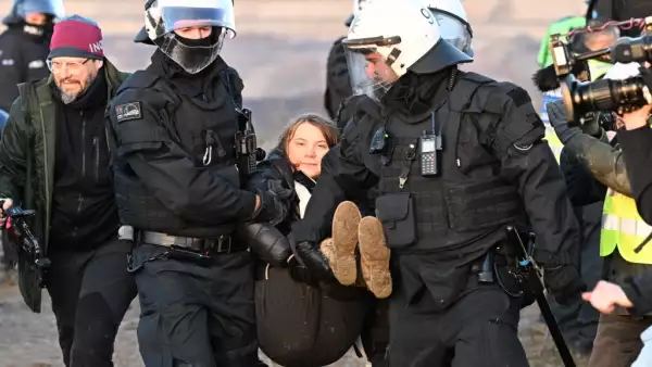 Dos agentes de la policía cargan a la activista climática sueca Greta Thunberg. 