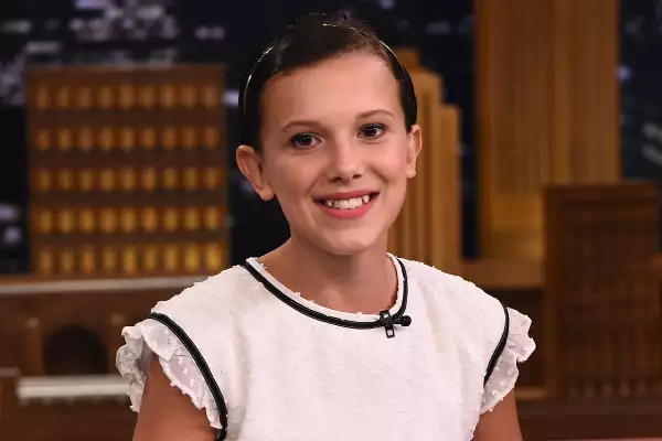 Foto de Millie Bobby Brown con cabello corto, vestido blanco con olanes durante el programa SNL en 2016.