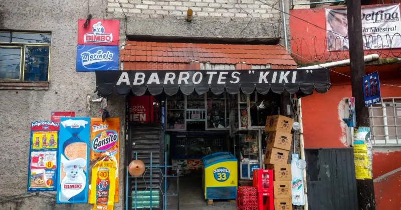 Fachada de tienda de abarrotes de nombre Kiki con letreros de Bimbo, Gansito, cajas de cerveza y refrescos.jpg
