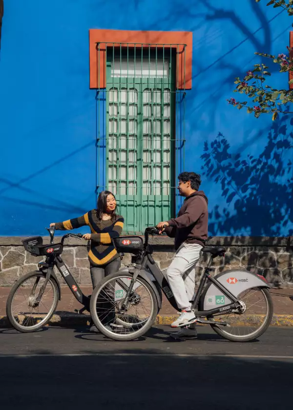 Dos personas en ECOBICI afuera del museo Cas Azul.jpg