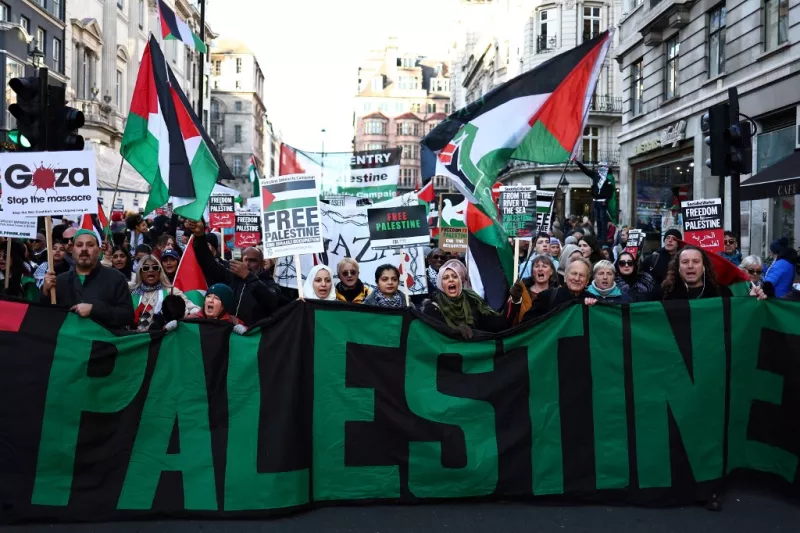 Los manifestantes con carteles y banderas palestinas participan en una "Marcha Nacional por Palestina" en el centro de Londres el 25 de noviembre de 2023, pidiendo un alto el fuego en el conflicto entre Israel y Hamas.