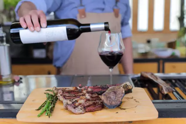 Cutting board with grilled beef and red wine