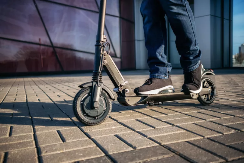 Close up view of legs of man on electric scooter