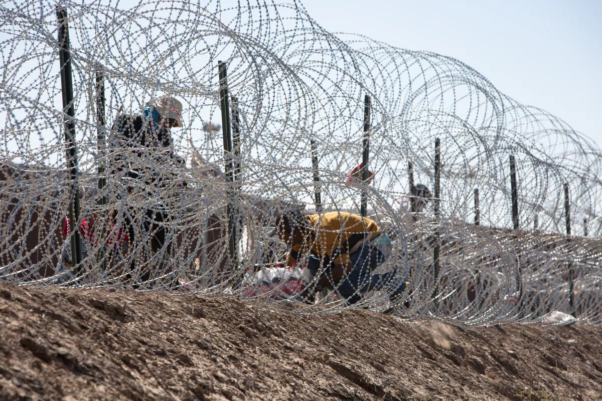 Migrantes se arriesgan a cruzar entre las púas y cuchillas