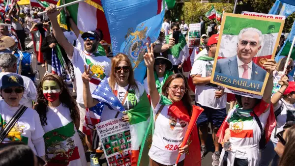 Un manifestante sostiene un cartel con un retrato del hijo del último sha de Irán, Reza Pahlavi, mientras la gente se manifiesta contra el régimen iraní fuera del Estadio de Los Ángeles (Estadio SoFi) antes del partido del torneo de fútbol americano de la Copa Mundial de 2026 entre Irán y Nueva Zelanda en Inglewood, California, el 15 de junio de 2026.