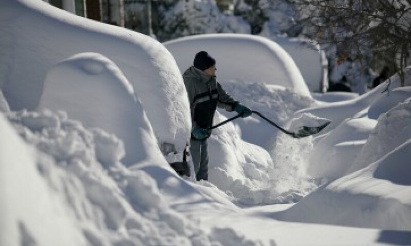 Un residente de Union City retira la nieve de la entrada de su casa, donde quedó sepultado su auto en New Jersey (Foto: Reuters)