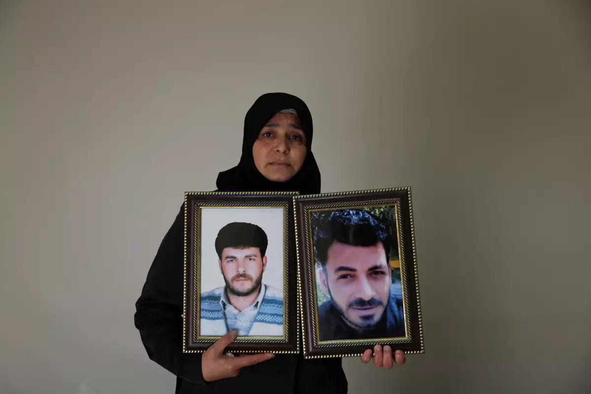 Amina Beqai, sosteniendo una foto de su esposo y su hermano, que desaparecieron después de ser arrestados por las fuerzas de seguridad bajo el gobierno del derrocado presidente derrocado Bashar al-Assad, en Damasco, Siria, el 23 de noviembre de 2025.