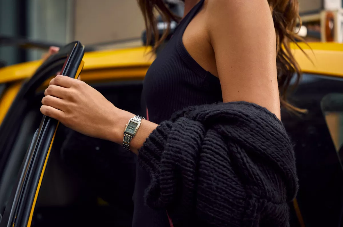 imagen de una joven subiendo a un taxi y portando un reloj Bulova Clásicos Sutton Acero.