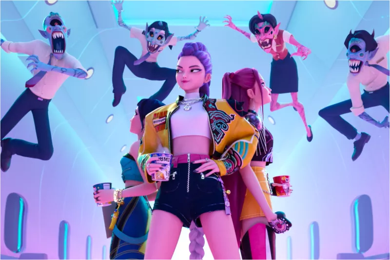Foto de una escena de la película animada 'Kpop Demon Hunters' con las protagonistas al centro y demonios volando sobre ellas.