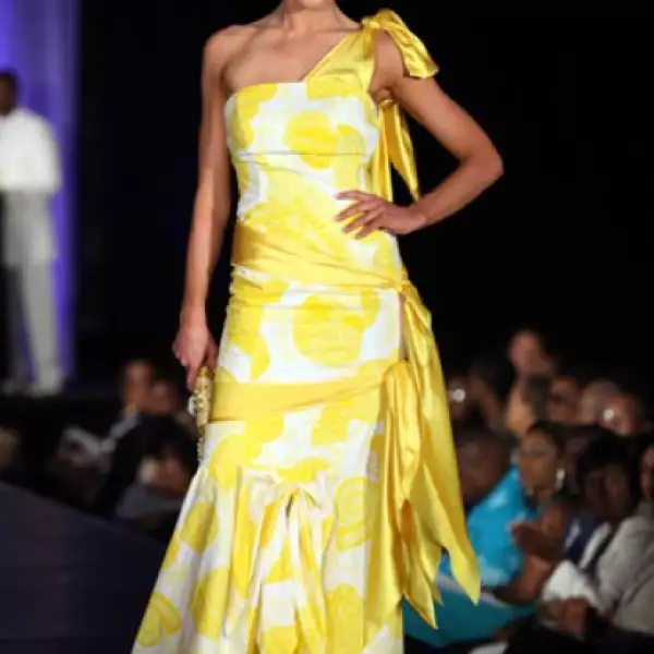 Ingibjorg Egilsdottir, de Islandia, en un vestido amarillo de un hombro y listones a tono en cintura y cadera.