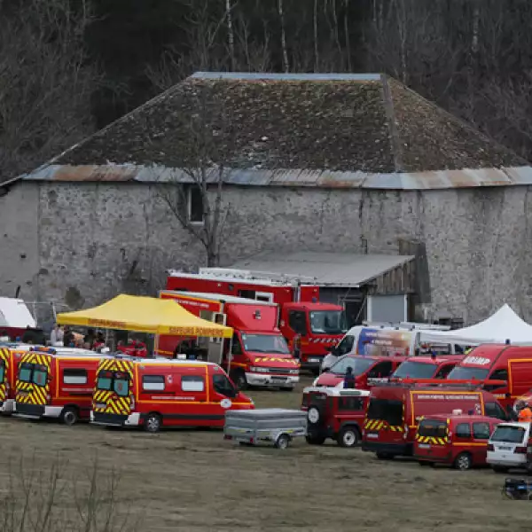 Unidades de rescate del cuerpo de bomberos franceses se reúnen en un campo cerca a de una granja y se preparan para llegar al lugar del accidente. 