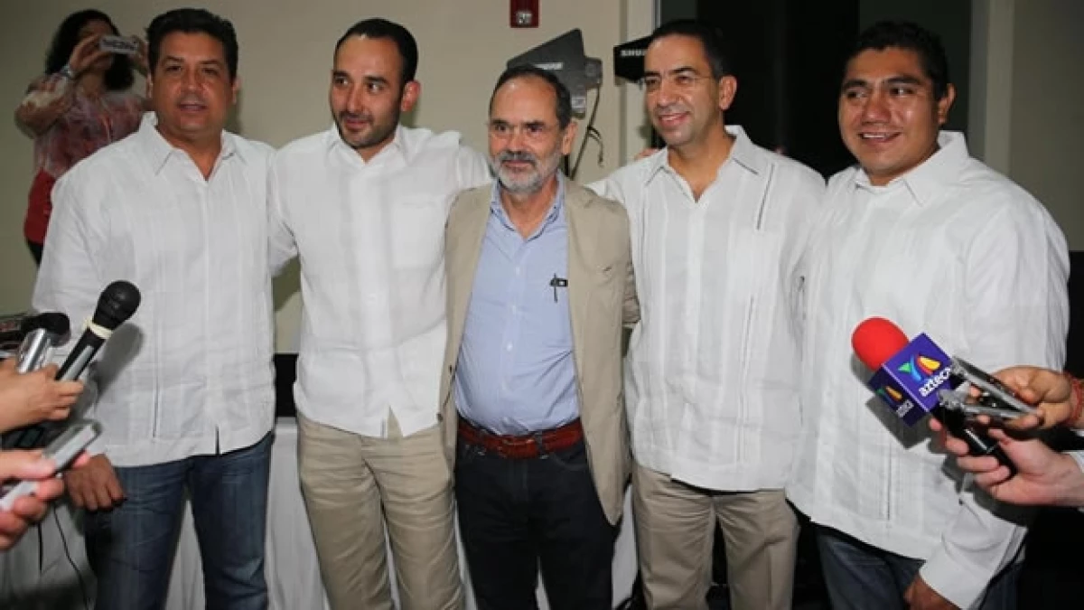 El líder nacional del PAN Gustavo Madero (centro), abrazando al senador Javier Lozano (segundo de derecha a izquierda) en un evento este jueves