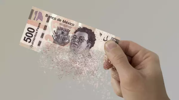 Mexican Pesos bill pulverizes in a man's hand.