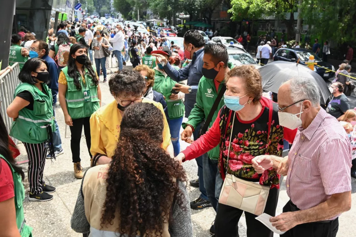 Una pareja de adultos mayores intenta entrar al centro de vacunación.