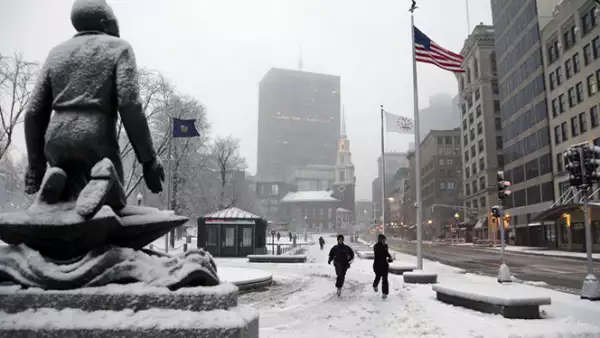 La visibilidad está severamente reducida, por lo que se han cancelado vuelos de diversas aerolíneas. Un par de corredores hacen ejercicio en Boston.