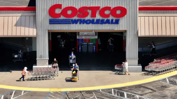 Clientes en Costco salen de hacer sus compras.