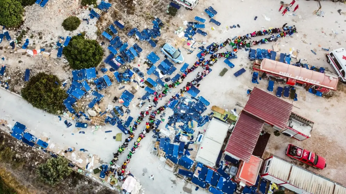 Esta fotografía aérea tomada el 14 de septiembre de 2023 muestra a los migrantes reuniéndose fuera del centro operativo llamado "Hotspot" en la isla italiana de Lampedusa.