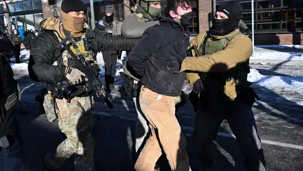 Un hombre es detenido por las fuerzas del orden, cerca del lugar donde las autoridades estatales y locales dicen que un hombre recibió un disparo por agentes federales temprano en la mañana en Minneapolis, Minnesota, el 24 de enero de 2026. El gobernador de Minnesota, Tim Walz, dijo el sábado que los agentes federales desplegados en Minneapolis como parte de una amplia represión de la inmigración habían llevado a cabo "otro tiroteo horrible", menos de tres semanas después del tiroteo fatal de Renee Good.