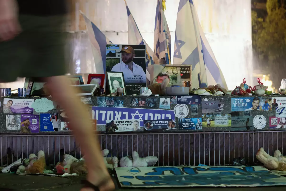 Un hombre mira caminando en la Plaza Dizengoff donde se exhiben recuerdos de rehenes secuestrados durante el ataque mortal del 7 de octubre, en Tel Aviv, Israel, el 11 de septiembre de 2024.