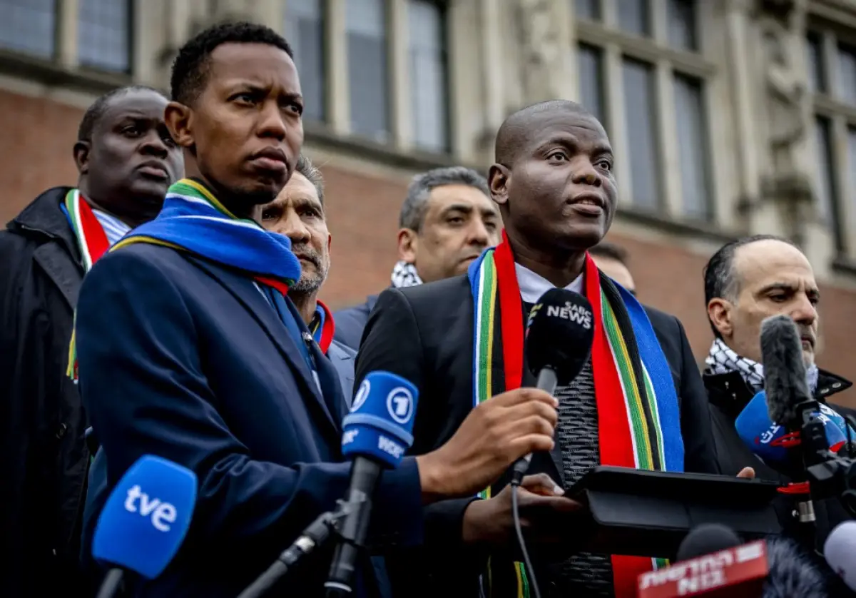 El Ministro de Justicia de Sudáfrica, Ronald Lamola (R), pronuncia comentarios a periodistas fuera de la Corte Internacional de Justicia (CIJ) después del primer día de audiencias sobre el caso de genocidio contra Israel presentado por Sudáfrica, en La Haya el 11 de enero de 2024.