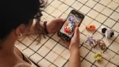 Una joven sostiene un celular entre sus manos.